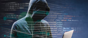 Hooded man looking at a laptop screen with code surrounding it